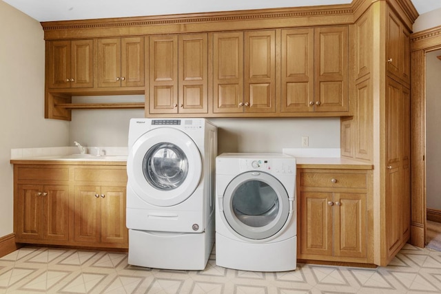 laundry area with sink, cabinets, and independent washer and dryer