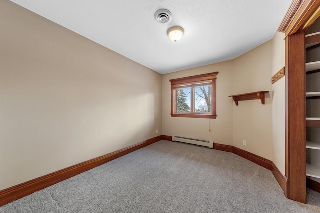 unfurnished room featuring carpet, lofted ceiling, and a baseboard heating unit