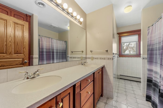 bathroom with tile patterned floors, vanity, tile walls, and a baseboard heating unit