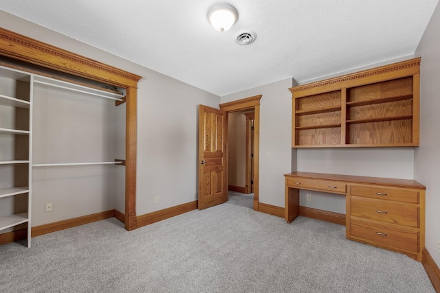 unfurnished bedroom featuring a textured ceiling and light carpet