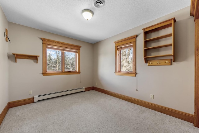 carpeted empty room featuring a baseboard radiator and a textured ceiling