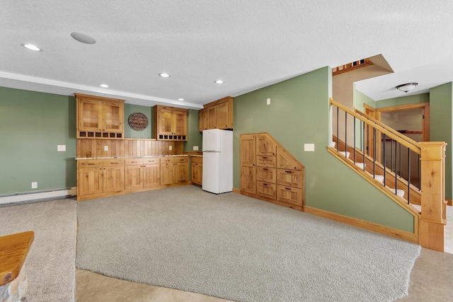 kitchen featuring baseboard heating, light colored carpet, a textured ceiling, and white refrigerator