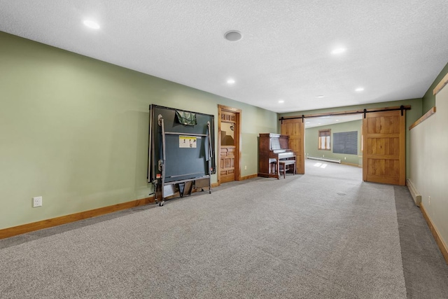 interior space with carpet, a textured ceiling, a barn door, and a baseboard radiator