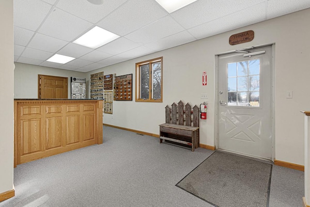 foyer featuring a drop ceiling and light carpet