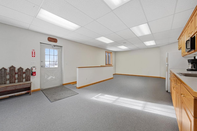 interior space featuring a drop ceiling and light colored carpet