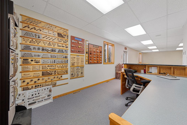 carpeted office with a paneled ceiling