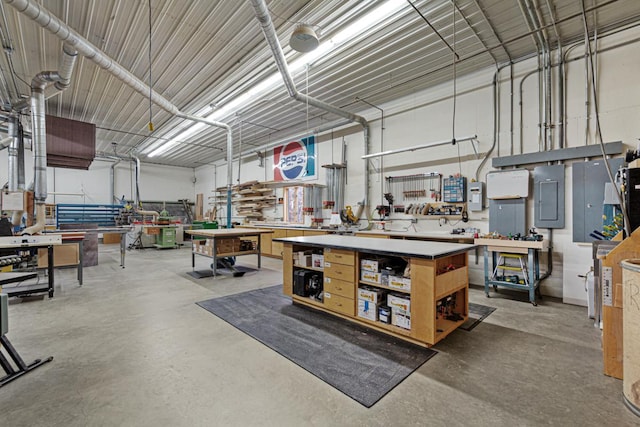 miscellaneous room featuring a workshop area, electric panel, and concrete floors