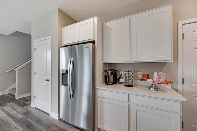 kitchen featuring white cabinetry, stainless steel fridge, wood-type flooring, and a textured ceiling