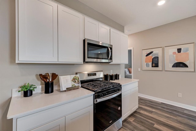 kitchen with white cabinets, dark hardwood / wood-style floors, and stainless steel appliances