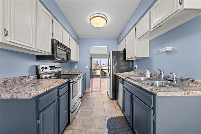 kitchen featuring white cabinets, light countertops, stainless steel appliances, and a sink