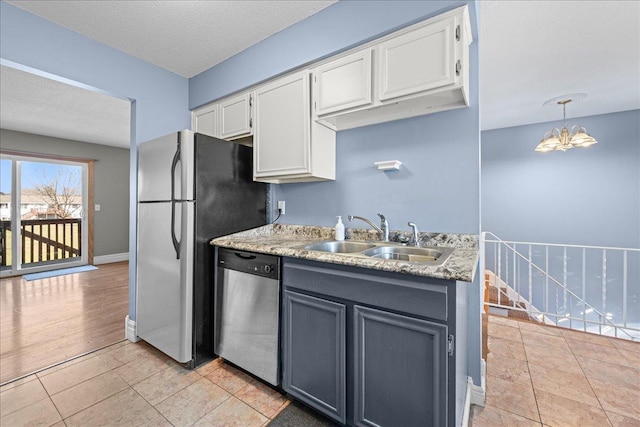 kitchen featuring white cabinetry, a chandelier, stainless steel appliances, and a sink