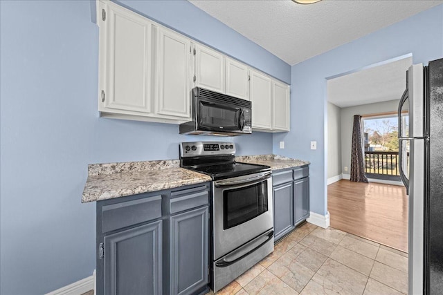 kitchen with light countertops, white cabinetry, stainless steel appliances, and gray cabinetry