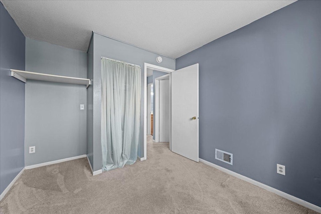 unfurnished bedroom featuring carpet floors, visible vents, and baseboards