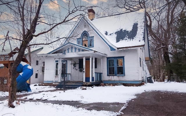 bungalow-style house with a chimney and a porch