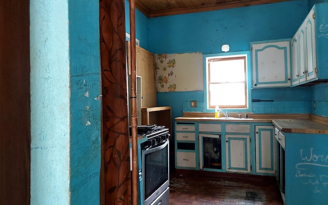 kitchen with white cabinets, a sink, and gas range