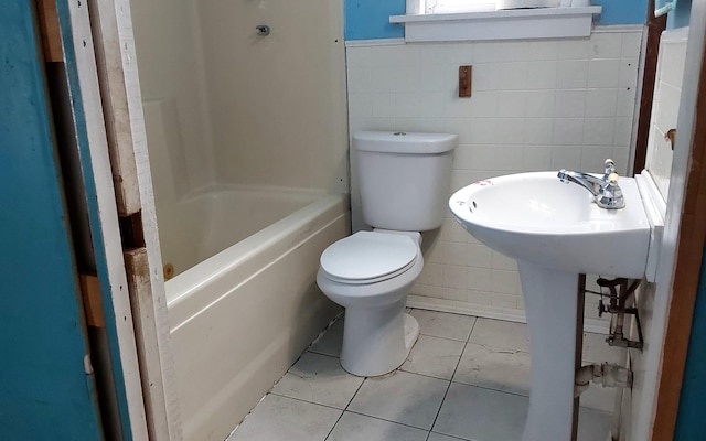 full bath with tile walls, toilet, tile patterned floors, and wainscoting