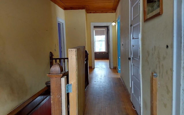hall with wood-type flooring and an upstairs landing