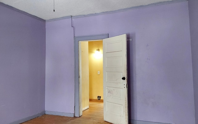 unfurnished room featuring wood finished floors and a textured ceiling