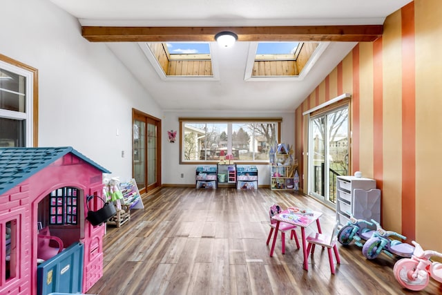 rec room with hardwood / wood-style floors and lofted ceiling with skylight