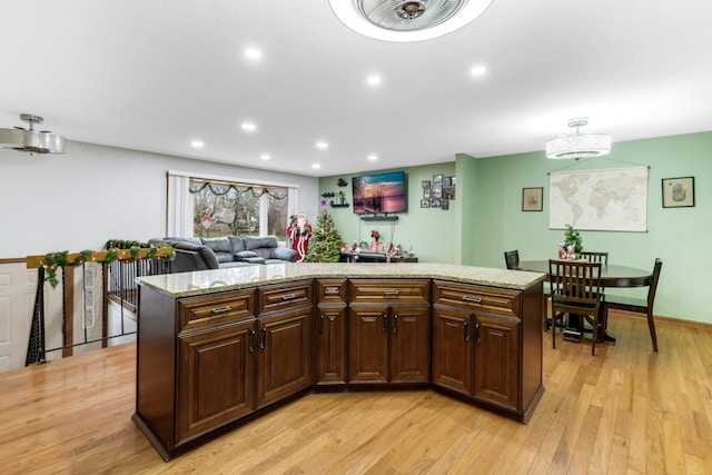 kitchen featuring light stone countertops, a center island, and light hardwood / wood-style floors