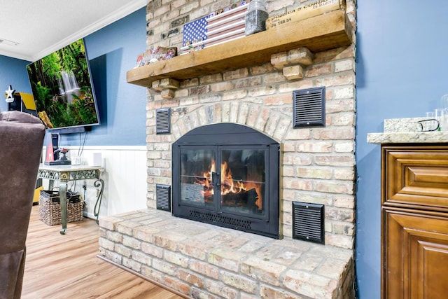 interior details with hardwood / wood-style flooring, crown molding, a brick fireplace, and a textured ceiling