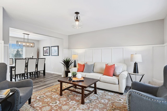 living room with hardwood / wood-style floors and an inviting chandelier