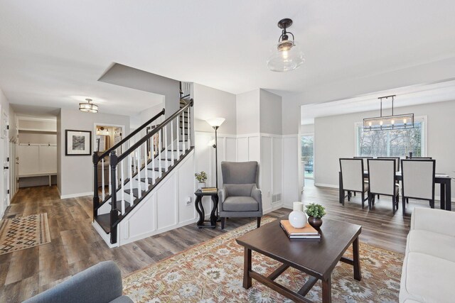 living room featuring a chandelier and dark hardwood / wood-style flooring