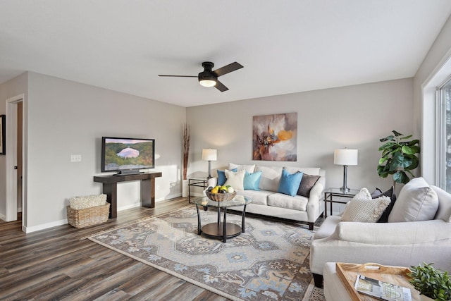 living room featuring ceiling fan and dark hardwood / wood-style flooring