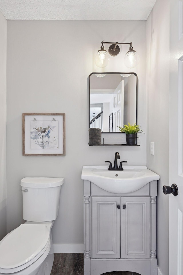 bathroom featuring hardwood / wood-style floors, vanity, a textured ceiling, and toilet