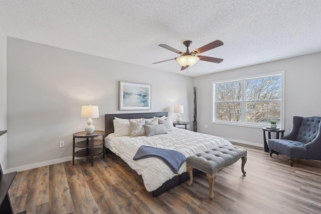 bedroom with a textured ceiling, dark hardwood / wood-style floors, and ceiling fan