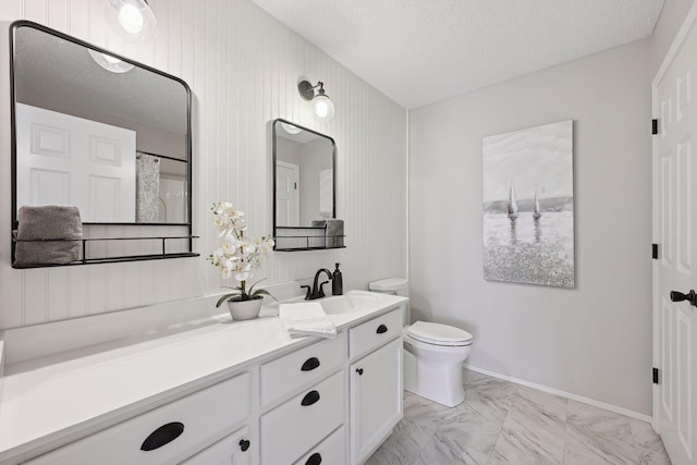 bathroom with vanity, a textured ceiling, and toilet