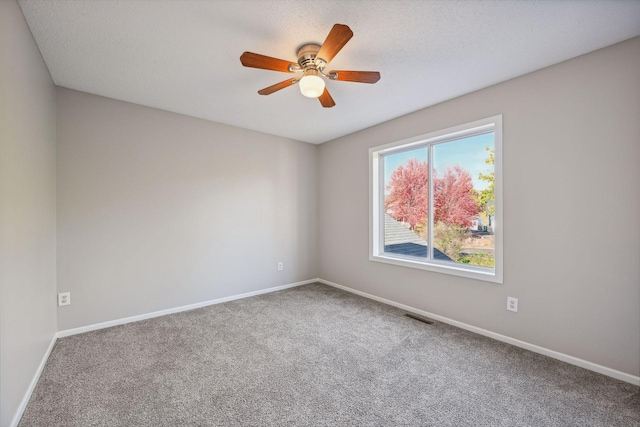 empty room with a textured ceiling, carpet floors, and ceiling fan