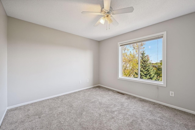 empty room with ceiling fan, carpet floors, and a textured ceiling