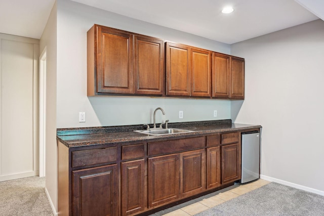 kitchen with light carpet, stainless steel refrigerator, and sink