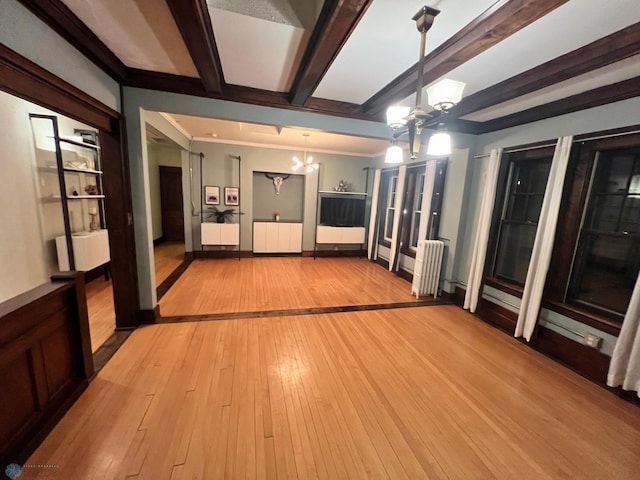 unfurnished living room with radiator, light hardwood / wood-style flooring, beamed ceiling, and an inviting chandelier