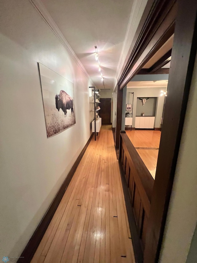 corridor featuring hardwood / wood-style floors, ornamental molding, and beamed ceiling