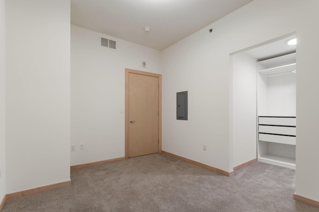 unfurnished bedroom with light colored carpet, electric panel, and a closet