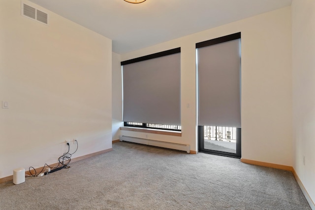 carpeted spare room featuring a baseboard heating unit