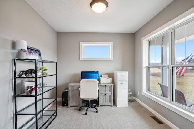 office space featuring carpet flooring, baseboards, and visible vents