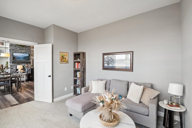 carpeted living area featuring baseboards