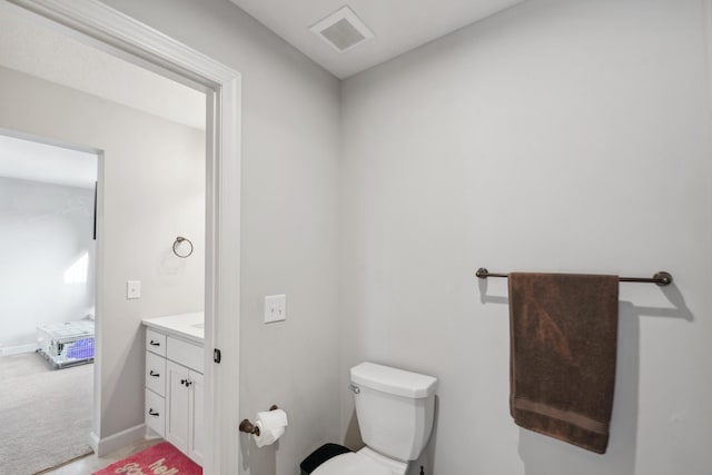 half bathroom with visible vents, baseboards, toilet, and vanity