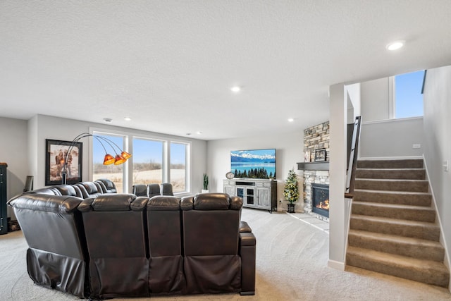 living area with stairway, light carpet, recessed lighting, a fireplace, and a textured ceiling