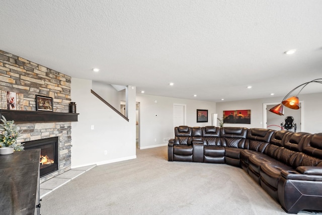 carpeted living room with recessed lighting, a fireplace, a textured ceiling, and baseboards