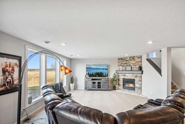 living room featuring a textured ceiling, a stone fireplace, baseboards, light colored carpet, and stairs