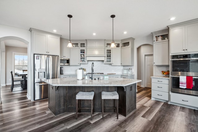 18340 Forest Rd N, Forest Lake, MN 55025 - kitchen featuring stainless steel appliances, arched walkways, dark wood-style flooring, and recessed lighting