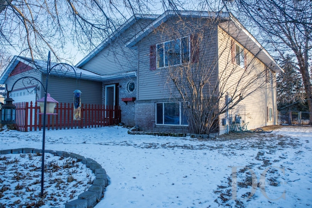 split level home with brick siding and fence