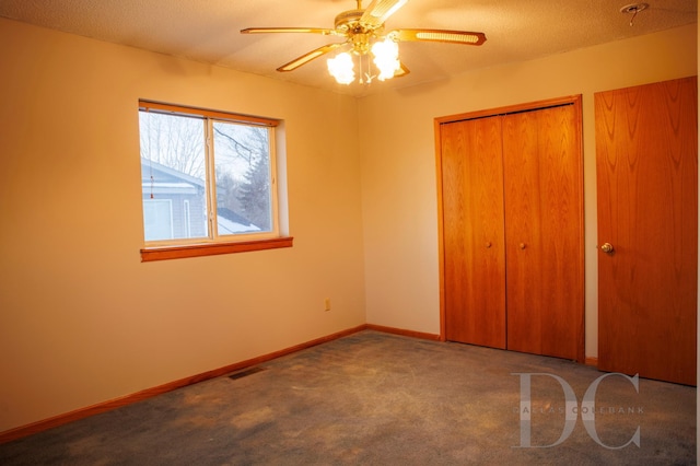 unfurnished bedroom with a textured ceiling, carpet flooring, visible vents, baseboards, and a closet