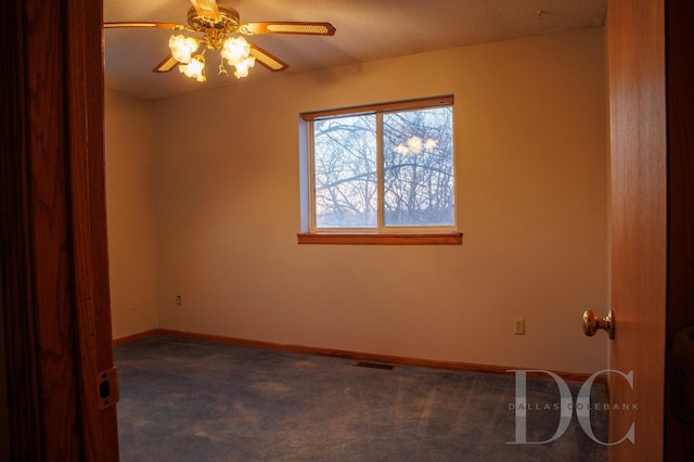 carpeted empty room with visible vents, a ceiling fan, and baseboards