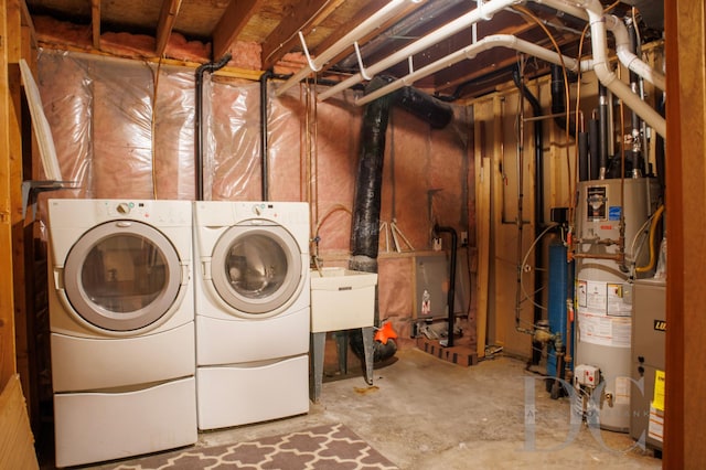 laundry room with water heater, laundry area, and washing machine and dryer