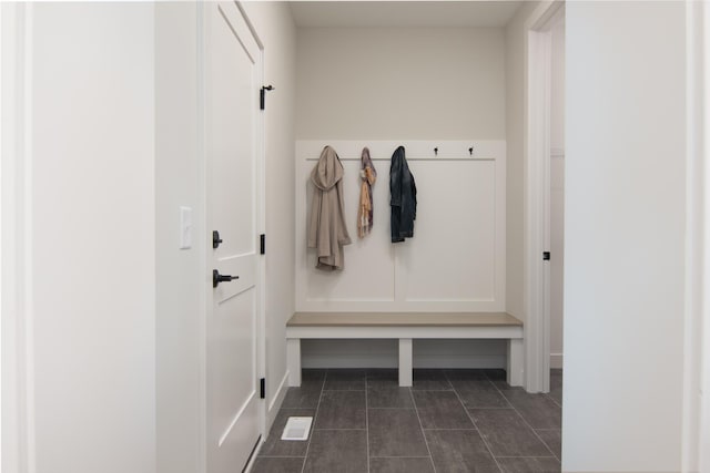 mudroom featuring dark tile patterned flooring